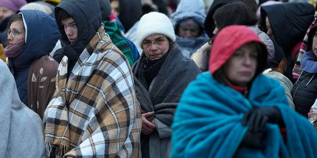 Refugees, mostly women and children, wait in a crowd for transportation after fleeing Ukraine and arriving at the border crossing in Medica, Poland, on March 7, 2022.
