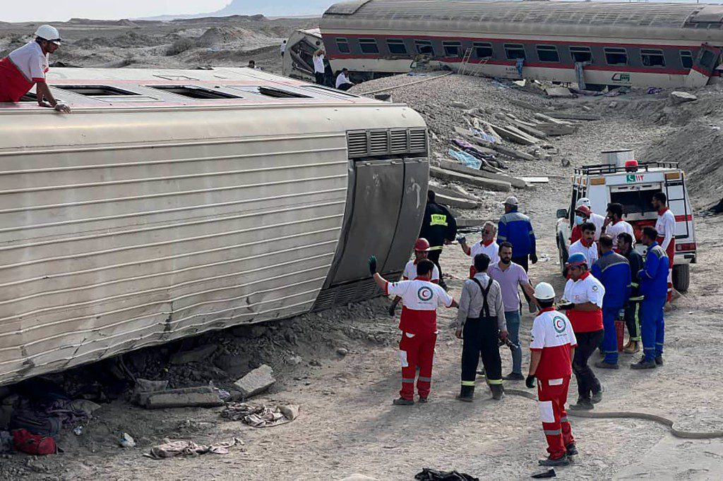 Rescue workers from the Iranian Red Crescent Society work at the site of the derailment.