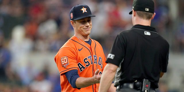 Houston Astros relief pitcher Phil Mattoon, left, has his hand checked for foreign matter as he heads to the dugout during the seventh inning of a baseball game against the Texas Rangers in Arlington, Texas, Wednesday, June 15, 2022. The Astros win 9-2. 