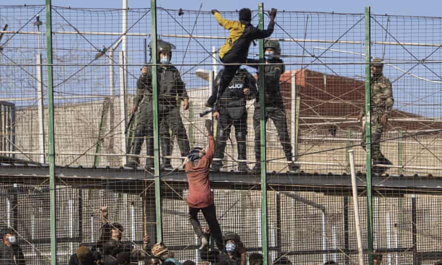 Migrants climb the walls separating Melilla and Morocco
