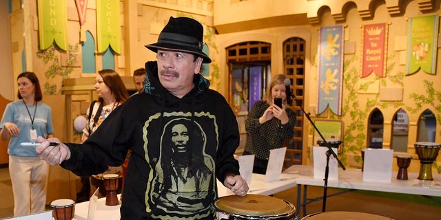 Artist Carlos Santana signs congressional autographs donated by him and his wife Cindy Blackman Santana to the Las Vegas Philharmonic while participating in the Philharmonic Orchestra's global version of the orKIDStra music education program for a group of students at the Children's Museum of Discovery on October 29, 2019 in Las Vegas, Nevada.  (Photo by Ethan Miller/Getty Images)