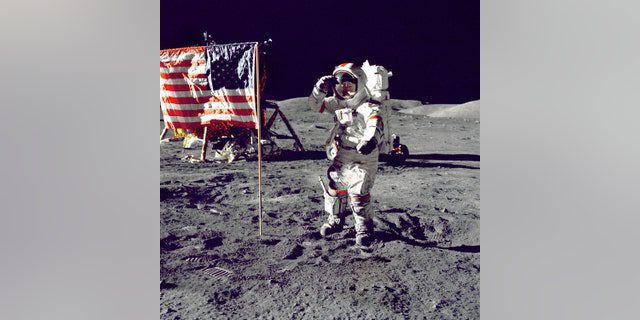 Astronaut Eugene A.  Cernan, the commander of Apollo 17, salutes the American flag on the lunar surface during extravehicular activity (EVA) on NASA's recent lunar landing mission.  lunar unit "Challenger" In the left background is the flag and the Lunar Rovers (LRV) also in the background.  Cernan was the last man to walk on the moon after completing the Apollo program. 