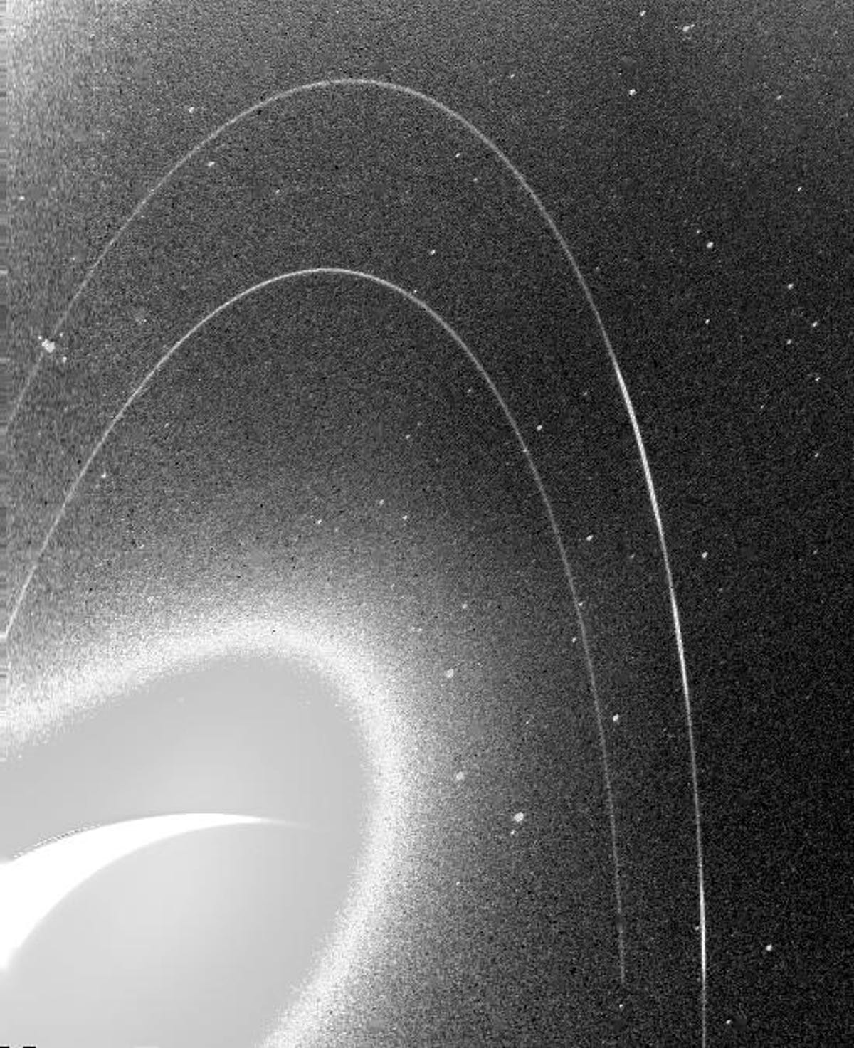 The grainy black and white image shows the faint rings of Neptune.