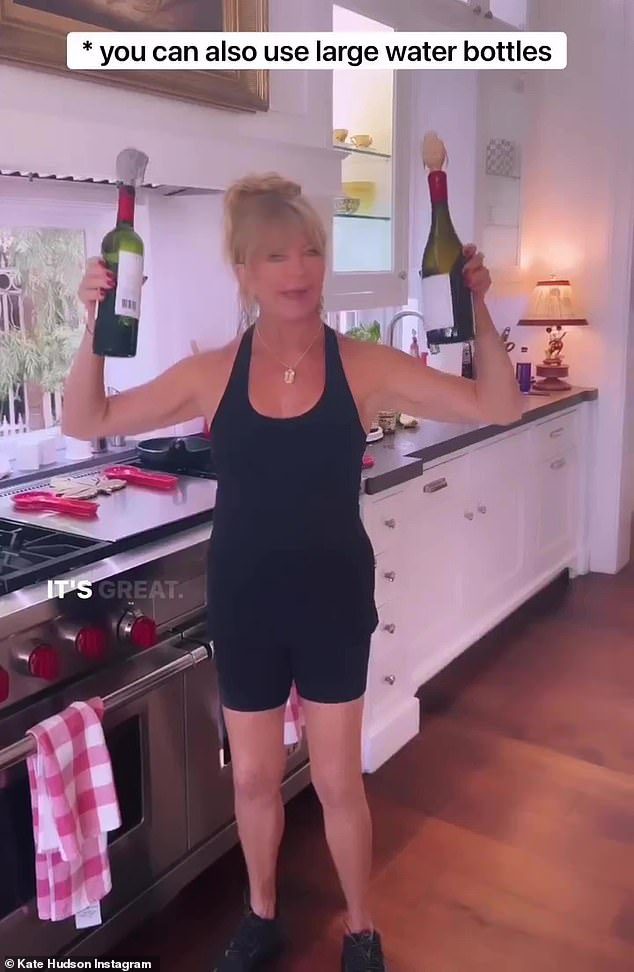 Pour it: Goldie also showed off her fun side by using wine bottles as weights