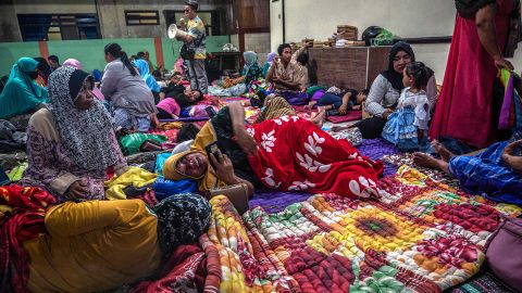 People take refuge in a community hall in Kandipuru village after the eruption of Mount Semeru volcano in Lumagang, East Java on December 4, 2022.
