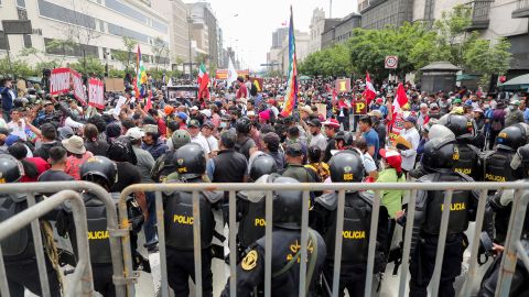Police officers stand guard as people gather outside Peru's Congress after President Pedro Castillo said he would dissolve the assembly on December 7.
