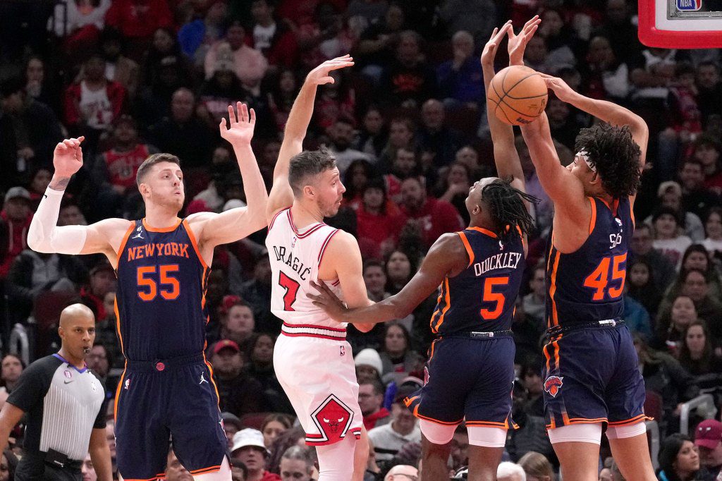 Goran Dragic of the Chicago Bulls passes the ball as New York Knicks' Isaiah Hartenstein (55), Emmanuel Kwekley (5) and Jericho Sims during the first half of an NBA basketball game Wednesday, December 14, 2022 in Chicago.  (AP Photo/Charles Rex Arbogast)